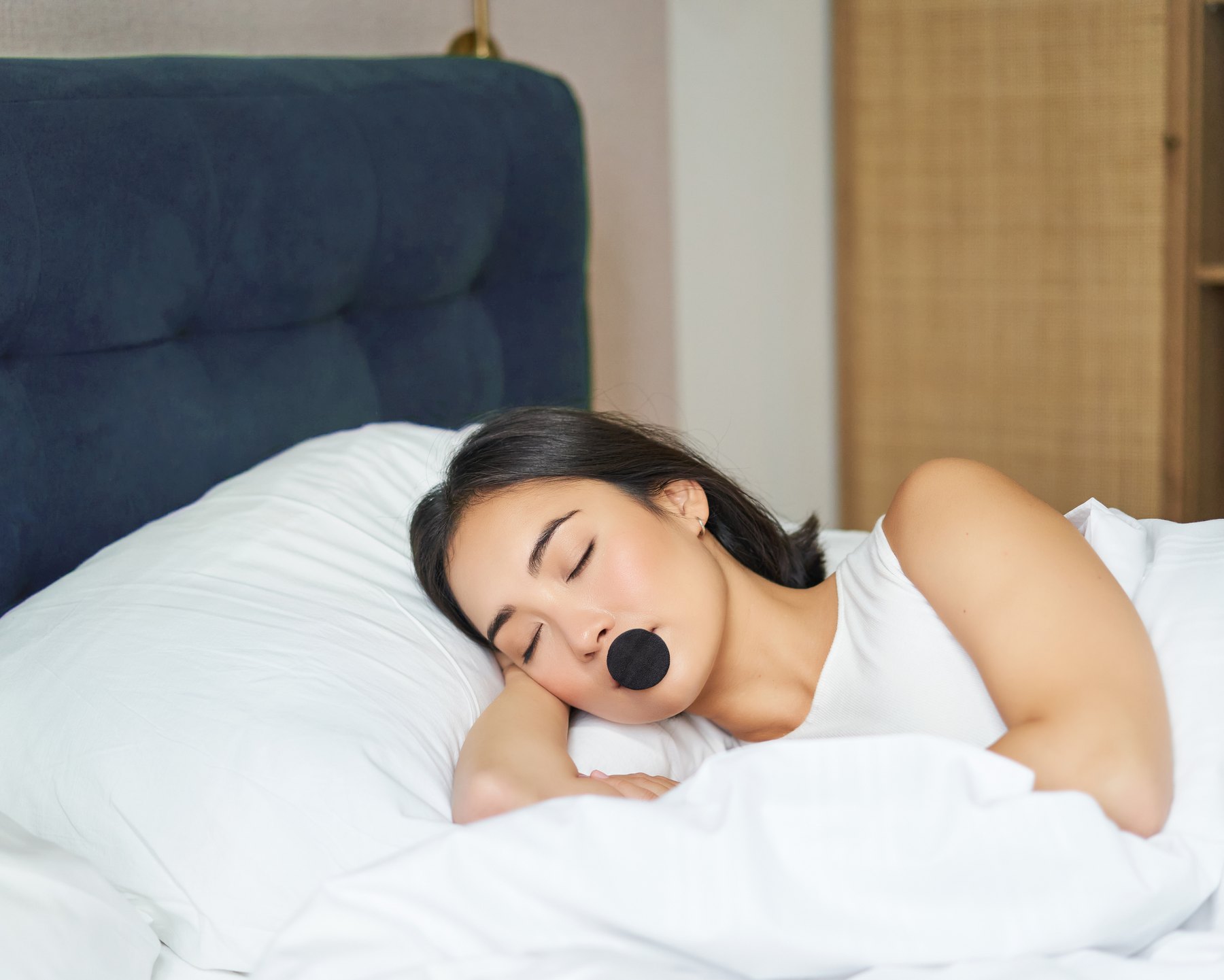 Woman asleep in bed wearing Mute Mouth Tape