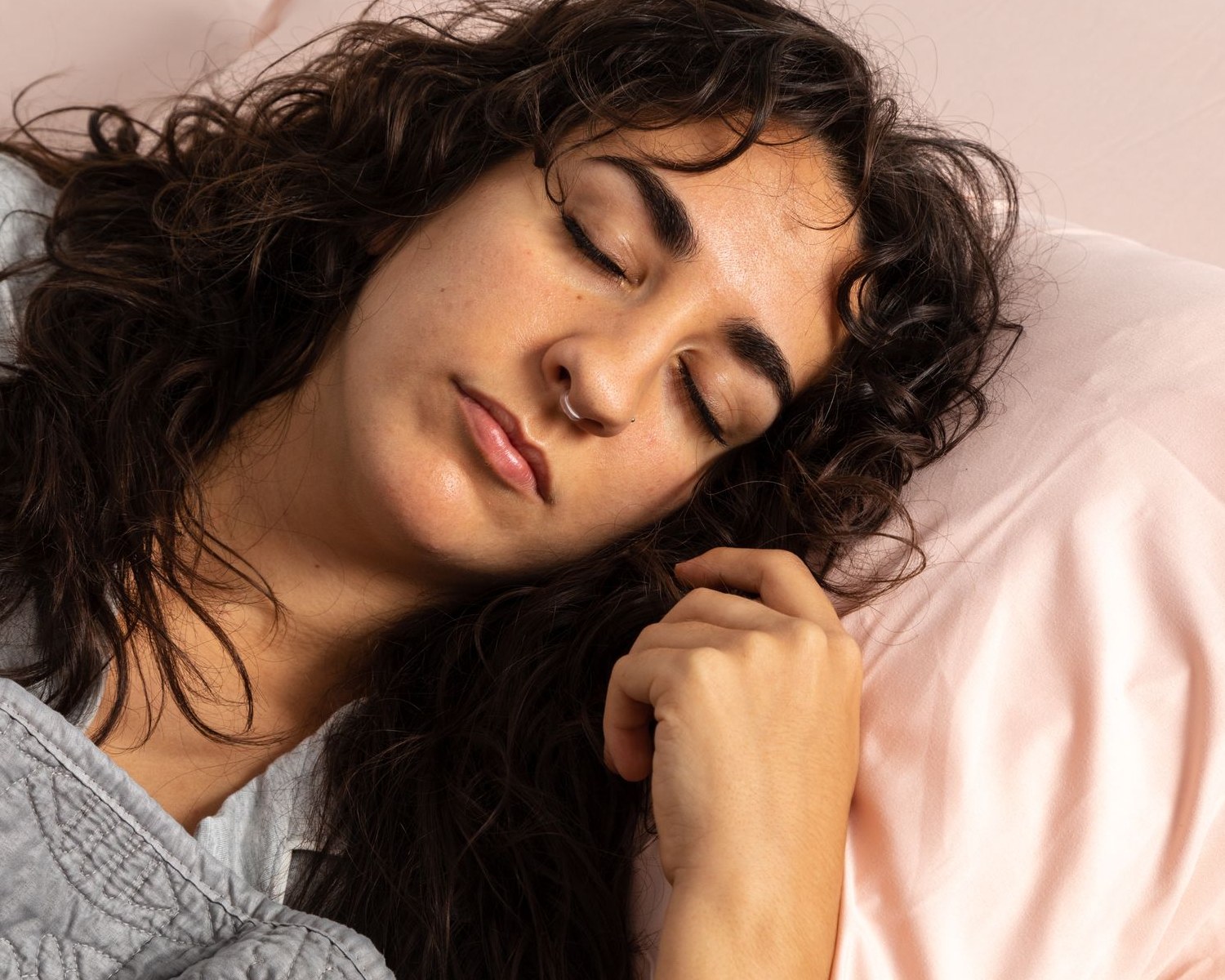 Woman asleep in bed wearing a Mute nasal dilator